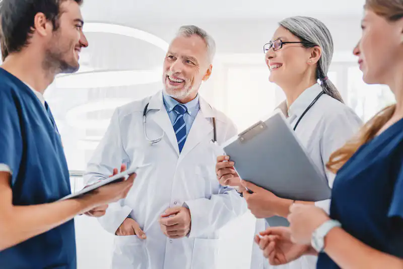 Multiracial-team-of-doctors standing in hallway discussing patient