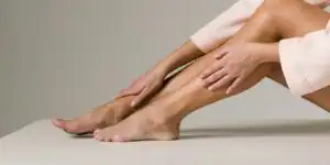 Woman sitting down touching her ankle