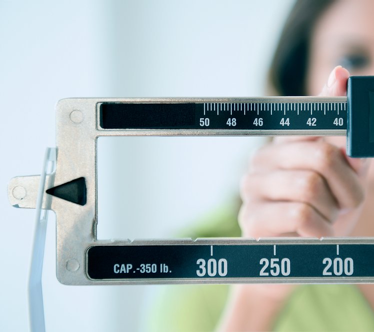 Woman pushing a scale to look at weight