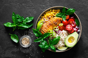 Healthy food bowl of corn, chicken, spinach, tomatoes, rice and avocado